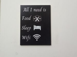 A decorative wall hanging with humorous text.